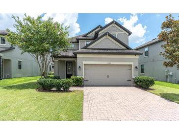 Charming two-story home features a well-manicured lawn, brick paved driveway and an attached two-car garage at 12382 Tibbetts St, Odessa, FL 33556