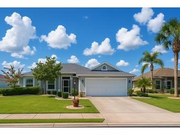 Charming single-story home featuring a well-manicured lawn, beautiful landscaping, and an attached two-car garage at 1607 Alexander Crossing Way, Sun City Center, FL 33573