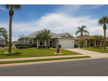 Charming single-story home with a well-manicured lawn, mature trees, and a two-car garage at 1607 Alexander Crossing Way, Sun City Center, FL 33573