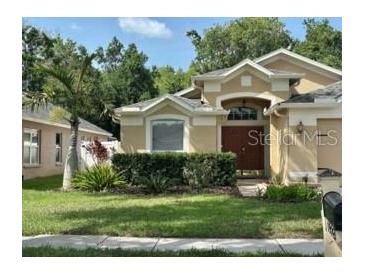 Charming single-Gathering home featuring a well-manicured lawn and lush landscaping at 19743 Ellendale Dr, Land O Lakes, FL 34638