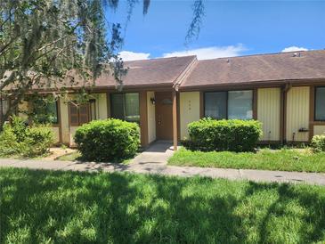 Inviting townhome featuring a well-maintained front yard and neutral tones at 209 Corkwood Ln Ln, Oldsmar, FL 34677