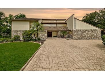 Contemporary home with stone accents, professional landscaping, and a brick driveway at 2103 N Golfview Dr, Plant City, FL 33566