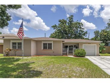 Charming single-story home with a well-manicured lawn and an American flag at 2415 York N St, St Petersburg, FL 33710
