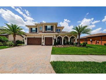 Stunning two-story home featuring a three-car garage, arched entryway, and professionally landscaped yard at 29038 Picana Ln, Wesley Chapel, FL 33543