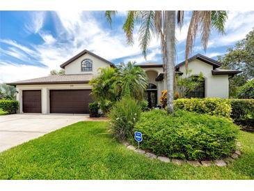 Beautiful single Gathering home with a well manicured yard, a two car garage, and mature landscaping in front at 335 Palmdale Dr, Oldsmar, FL 34677