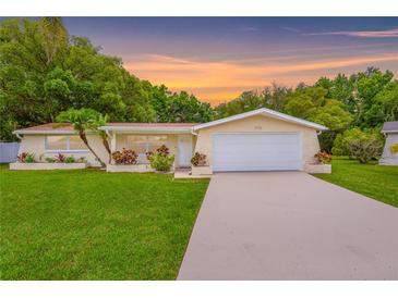 Charming single-story home with well-manicured lawn, mature trees, and a two car garage at 5102 Peacock, Holiday, FL 34690