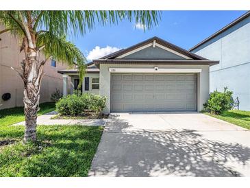 Charming single-story home featuring a well-maintained lawn and a spacious two-car garage at 7211 Ozello Trail Ave, Sun City Center, FL 33573
