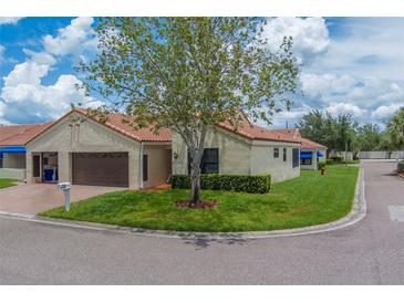 Charming villa with a well-maintained lawn, mature tree, and a barrel tile roof at 8701 40Th N Ln, Pinellas Park, FL 33782