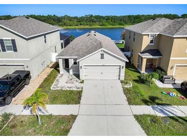 Charming single-Gathering home featuring a two-car garage and a view of the tranquil lake at 10024 Merry Fawn Ct, Sun City Center, FL 33573