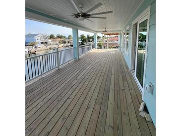 Spacious covered porch with ceiling fans and canal views, perfect for outdoor relaxation and entertaining at 15550 Bertram Dr, Hudson, FL 34667