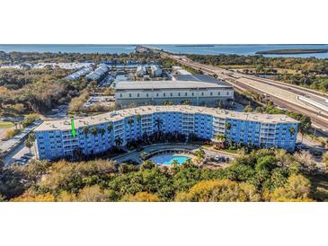 Scenic view of the condo building with a pool and lush landscaping, near the bay and highway at 3315 58Th S Ave # 421, St Petersburg, FL 33712