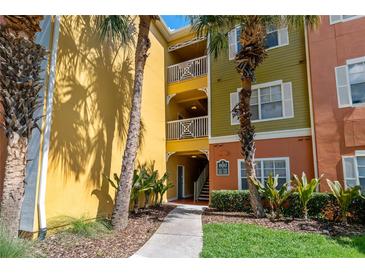 Condo building with multiple levels featuring colorful facades, tropical landscaping, and walkways at 4207 S Dale Mabry Hwy # 8304, Tampa, FL 33611