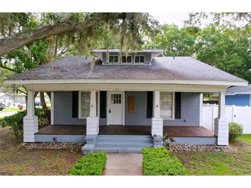 Charming single-story home featuring a welcoming front porch and beautiful, mature landscaping at 606 N Merrin St, Plant City, FL 33563