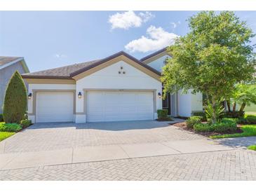 Charming home featuring a three-car garage and brick-paved driveway, complemented by well-maintained landscaping at 6331 Voyagers Pl, Apollo Beach, FL 33572
