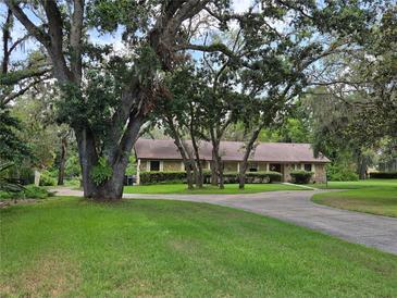 Ranch style home with circular driveway, mature trees and professional landscaping at 11307 Sandpine Rd, Riverview, FL 33569