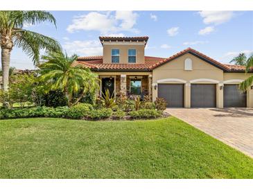 Charming, one-story home boasts a terracotta roof, three-car garage, and lush landscaping at 165 Mobbly Bay Dr, Oldsmar, FL 34677