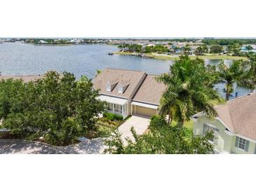 Waterfront home featuring lush landscaping, neutral paint, and a two-car garage at 5205 Brighton Shore Dr, Apollo Beach, FL 33572