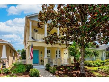 Charming two-story home with a colorful front door, columns, and nicely landscaped front yard at 5410 River Sound Ter, Bradenton, FL 34208