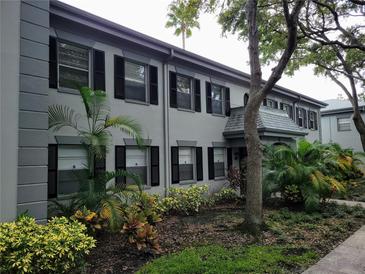 Beautiful exterior elevation with manicured landscaping and elegant gray paint scheme at 6925-A Avenue Des Palais # 1A, South Pasadena, FL 33707