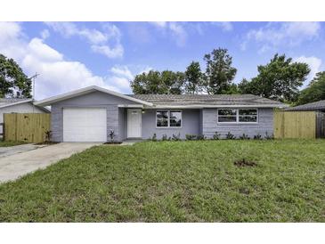 Charming single-story home featuring a gray exterior, well-maintained lawn, and attached garage at 7625 Marechal Ave, Port Richey, FL 34668