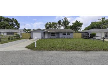 Exterior of a single-story house with a well-kept lawn and an attached garage at 7625 Marechal Ave, Port Richey, FL 34668
