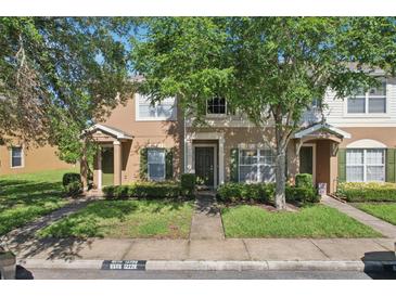 Inviting townhome with green shutters, a front lawn, and shade trees enhancing its curb appeal at 12228 Foxmoor Peak Dr, Riverview, FL 33579