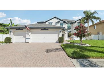 Charming two-story home with a three car garage, beautiful landscaping, and manicured lawn at 1802 Regal Mist Loop, Trinity, FL 34655