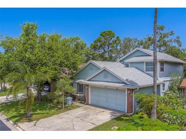 Charming home featuring well-maintained landscaping, mature trees, and an attached two-car garage at 1830 Springwood N Cir, Clearwater, FL 33763