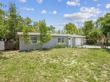 Charming single-story home with a well-manicured lawn and mature trees, perfect for serene living at 1843 Berg Rd, Holiday, FL 34690