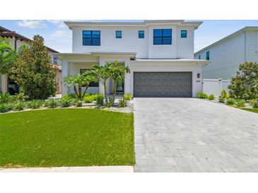 Stunning two-story home with manicured lawn, paver driveway, and gray garage door at 4109 W Inman Ave, Tampa, FL 33609