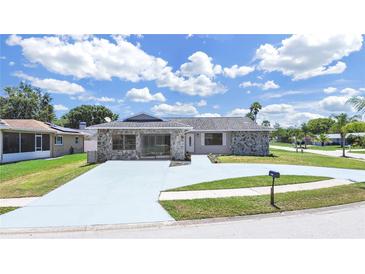 Charming single-story home boasting stone accents, a spacious driveway, and well-maintained landscaping at 4652 Swallowtail Dr, New Port Richey, FL 34653