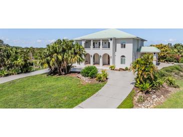 Stunning two-story home with a well-manicured lawn, a long driveway, and lush tropical landscaping at 4710 Troydale Rd, Tampa, FL 33615