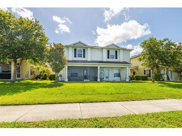 Charming two-story home featuring a well-manicured lawn and covered porch with a screened in lanai at 4743 Somerset Hill Ln, Riverview, FL 33578