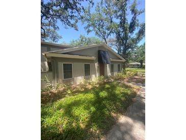 Charming single-story home with a neutral color scheme, awning, and mature landscaping for added privacy at 6214 Dewdrop Way # 621, Temple Terrace, FL 33617