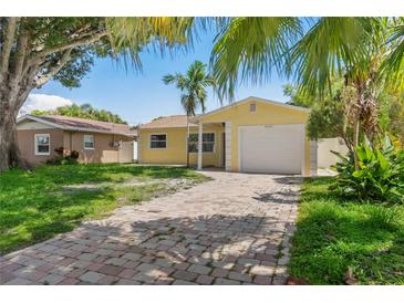 Charming yellow single Gathering home with a brick driveway and a one car garage at 4242 7Th N Ave, St Petersburg, FL 33713