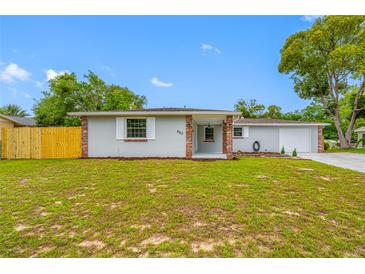 Charming single Gathering home with a well maintained lawn, neutral paint, brick details and attached garage at 4313 Riviera Ct, Spring Hill, FL 34608