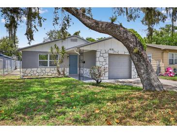 Charming single-story home featuring stone accents, a well-maintained lawn, and mature tree providing shade at 4535 15Th S Ave, St Petersburg, FL 33711