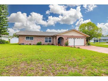 Charming single-story brick home featuring a well-manicured lawn and an attached two-car garage at 314 Circle Dr, Palm Harbor, FL 34683
