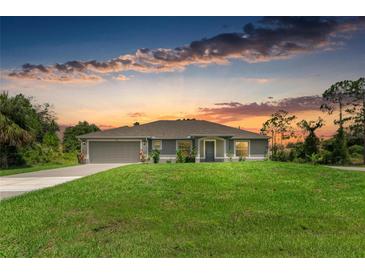 Charming single-story home featuring a well-maintained lawn, neutral tones, and an attached two-car garage at 3682 Johnstown St, North Port, FL 34288