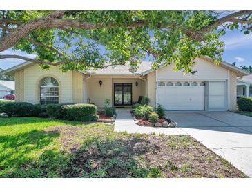 Charming single-story home boasts a manicured lawn and an attached garage at 4712 Coachmen Rd, New Port Richey, FL 34655