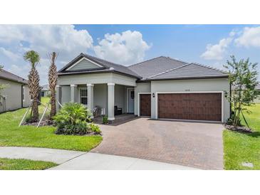 Charming single-story home featuring a brick-paved driveway and a welcoming covered porch with classic columns at 10278 Otter Sky Ct, San Antonio, FL 33576