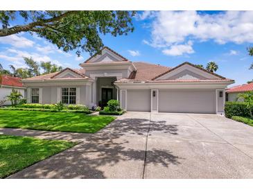 Charming single-story home with tile roof, well-manicured lawn and a three-car garage at 17807 Arbor Greene Dr, Tampa, FL 33647