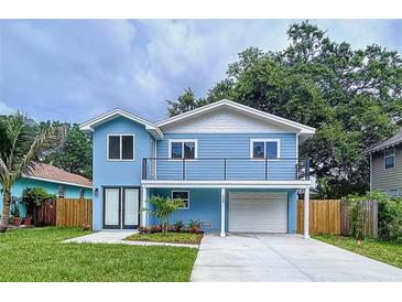 Charming two-story blue home featuring a second story balcony, white trim and an attached garage at 309 Congress St, Oldsmar, FL 34677