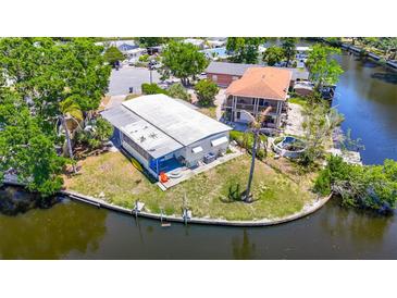 Waterfront property with boat dock, lush landscaping, and screened-in patio offers serene coastal living at 5806 Portsmouth Dr, Tampa, FL 33615