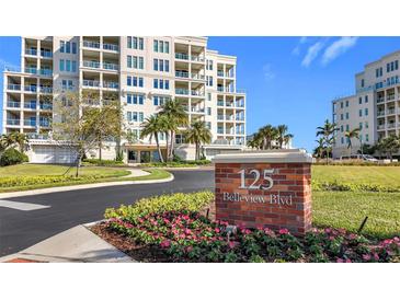 Beautiful condominium building with lush landscaping and a prominent street address sign at 125 Belleview Blvd # 503, Belleair, FL 33756