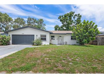 Charming single-story home with a well-maintained lawn and a gray two-car garage at 1586 Linwood Dr, Clearwater, FL 33755