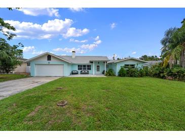 Charming light blue single story home with a well-manicured lawn and a spacious driveway at 1825 Welland Dr, Clearwater, FL 33756