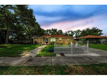 Charming single-story home with a well-manicured lawn and a cute white picket fence, enhancing its curb appeal at 1893 Harding St, Clearwater, FL 33765