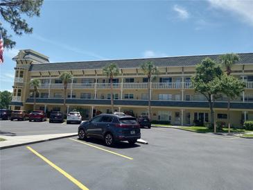Condo building exterior with parking lot, palm trees and well maintained landscaping on a sunny day at 2459 Franciscan Dr # 29, Clearwater, FL 33763