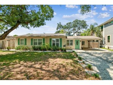 Charming single-story home featuring a light yellow exterior, green shutters, and a welcoming front yard at 4417 W El Prado Blvd, Tampa, FL 33629